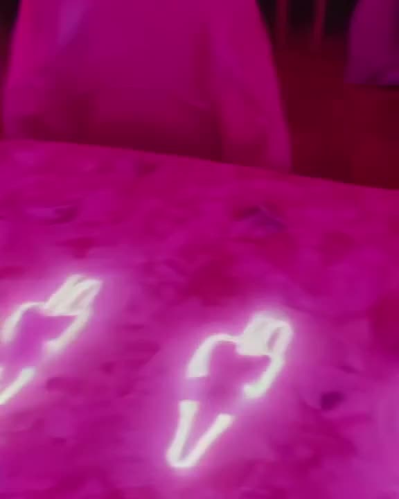 A pair of sunglasses slides across a table, leaving a trail of glowing neon footprints th…