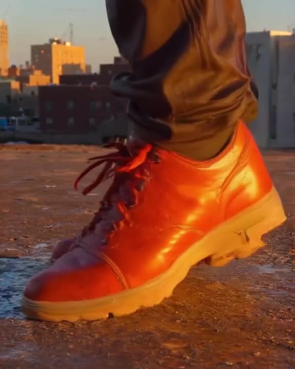 A sneaker performs an intricate footwork routine on a gritty urban rooftop. Golden hour s…
