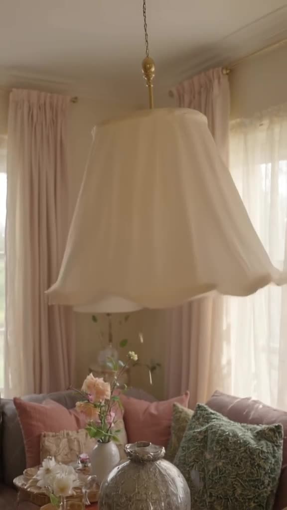 A lampshade sways rhythmically, doing a soft body roll in a cozy living room. Soft aftern…