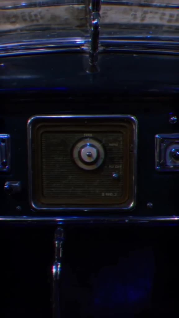 A vintage car radio dial turns smoothly, dialing through stations that play different ani…