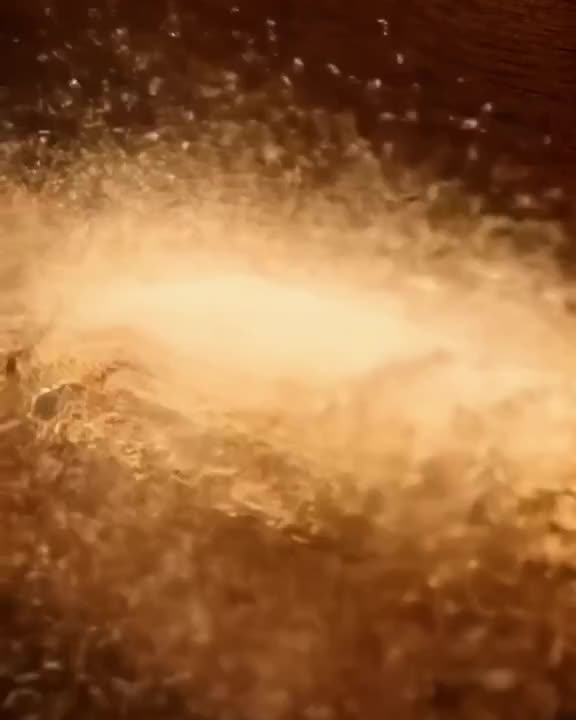 Miniature ants march across a giant cinnamon stick, kicking up a cloud of brown powder th…