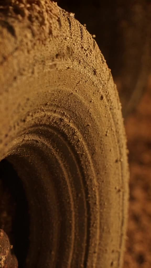 A documentary-style close-up of a car tire spinning, but the tread is made of sprinkles t…
