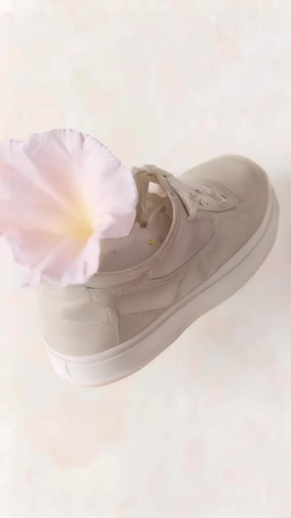 A sneaker blooms like a flower, petals made of canvas unfolding to reveal a heart made of…