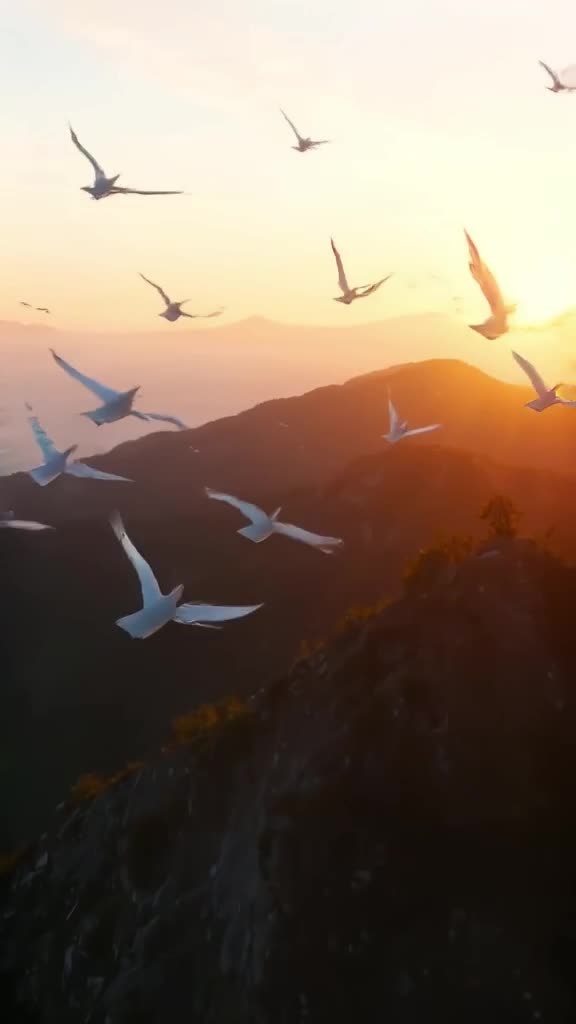 A drone follows a flock of paper cranes gliding over a mountain range at sunset. Realisti…