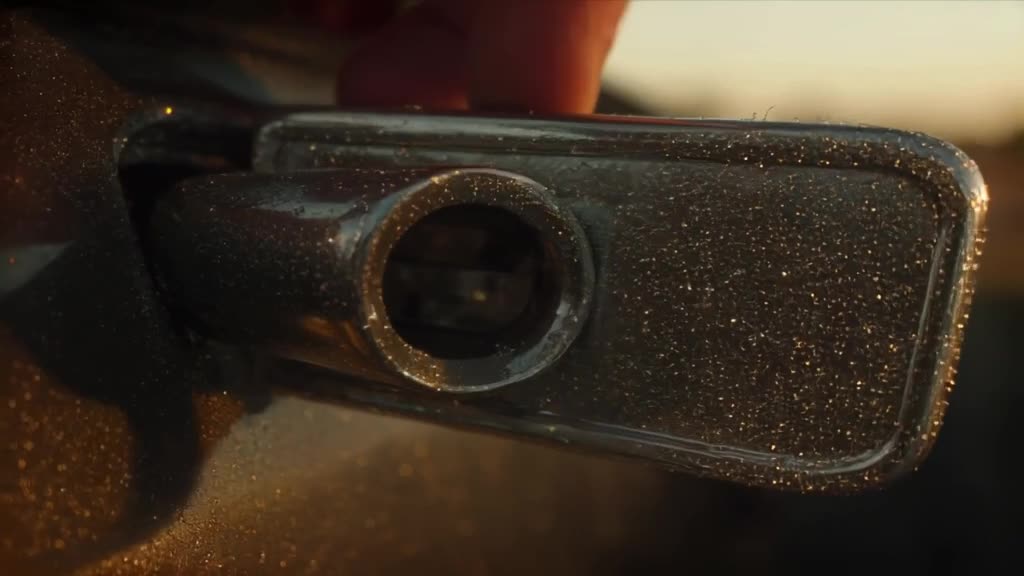 A vintage 1960s Mustang door hinge is shown in extreme close-up, sparkling with diamond d…