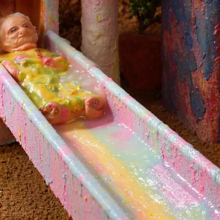 Claymation scene of an elderly person sliding down a slide made of gelatin. The jelly wob…