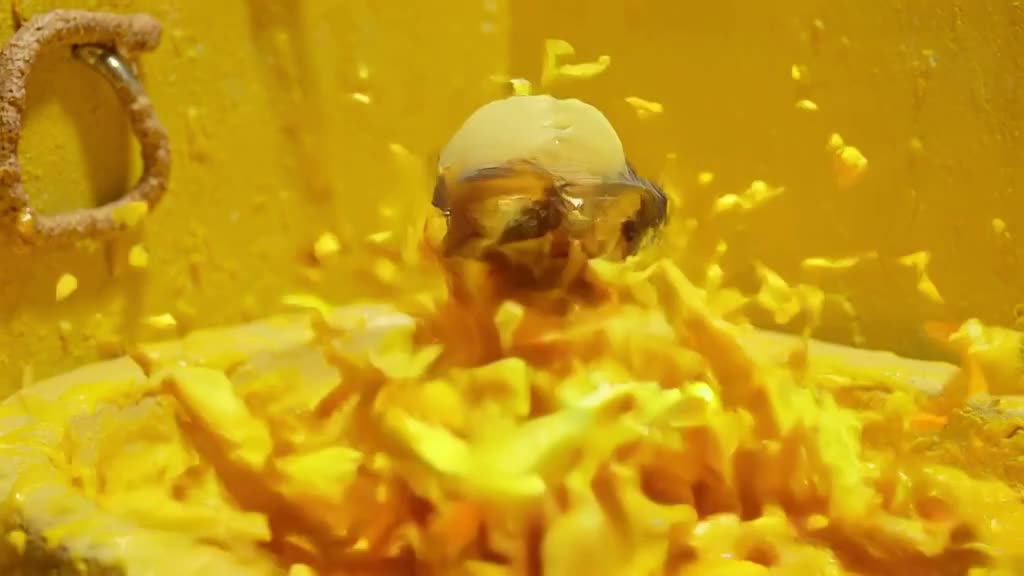 A claymation duck wearing goggles dives into a bathtub of yellow paint. It emerges coated…