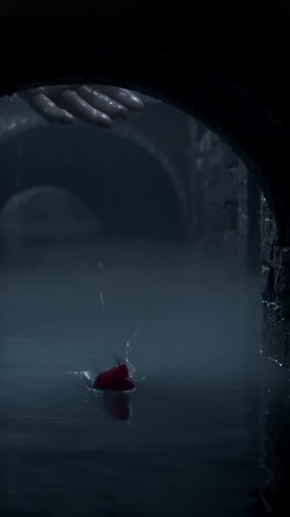 A single red rose floats down a dark, misty Venetian canal. As it passes under a bridge, …