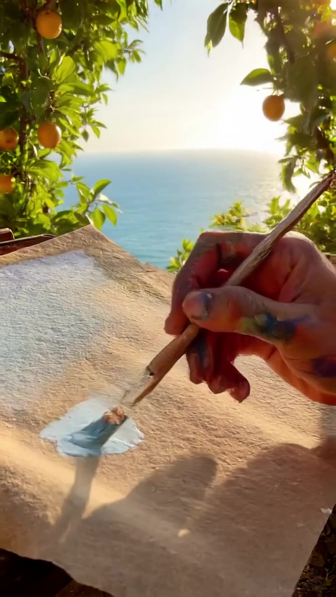 an artist is painting a picture: sea, beautiful sunny beach, lemon trees around