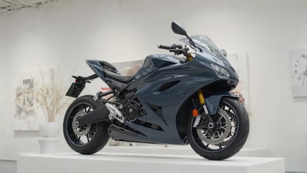 A sleek Ducati rests on a pedestal in a white art gallery. A bee buzzes in, lands on the …