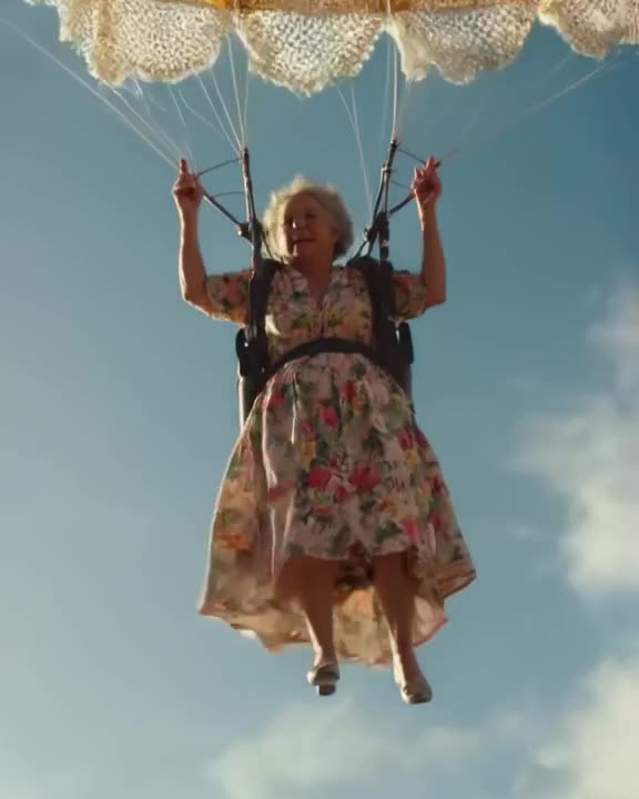 A 90-year-old grandmother in a vintage floral dress skydiving over the Caribbean. She dep…