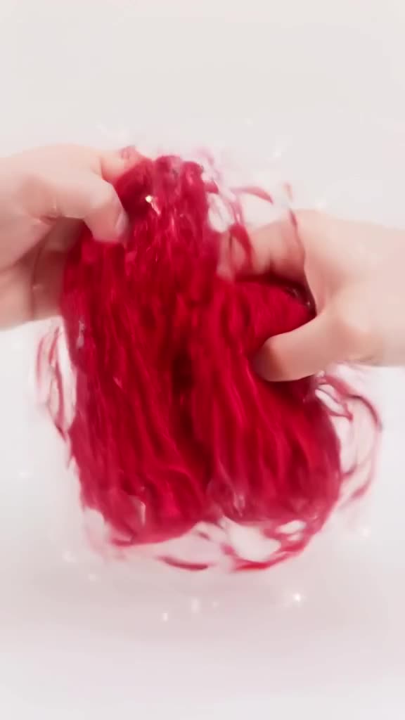 A pair of wool socks is knitted by invisible hands in mid-air. Stitches form rapidly with…