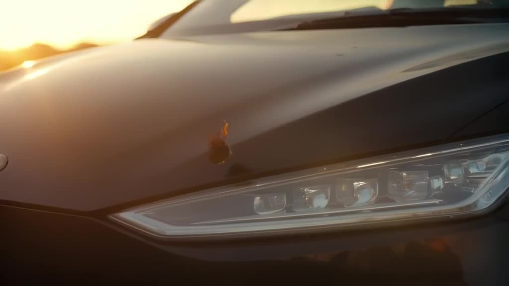 Cinematic slow-motion shot of a butterfly landing on the headlight of a matte black elect…
