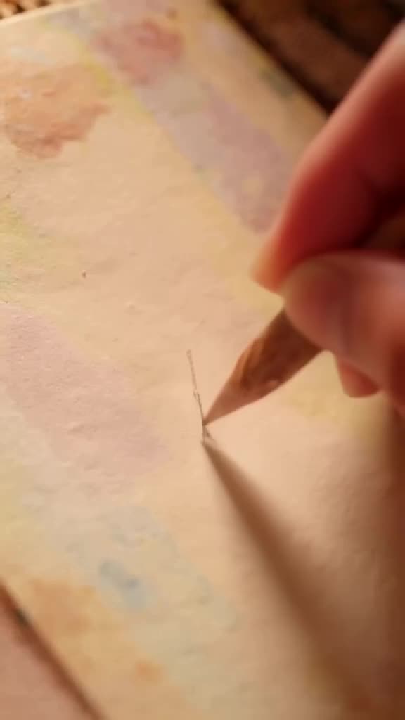 A sketchbook draws itself. The pencil lifts off the paper, dips into an inkwell, and draw…