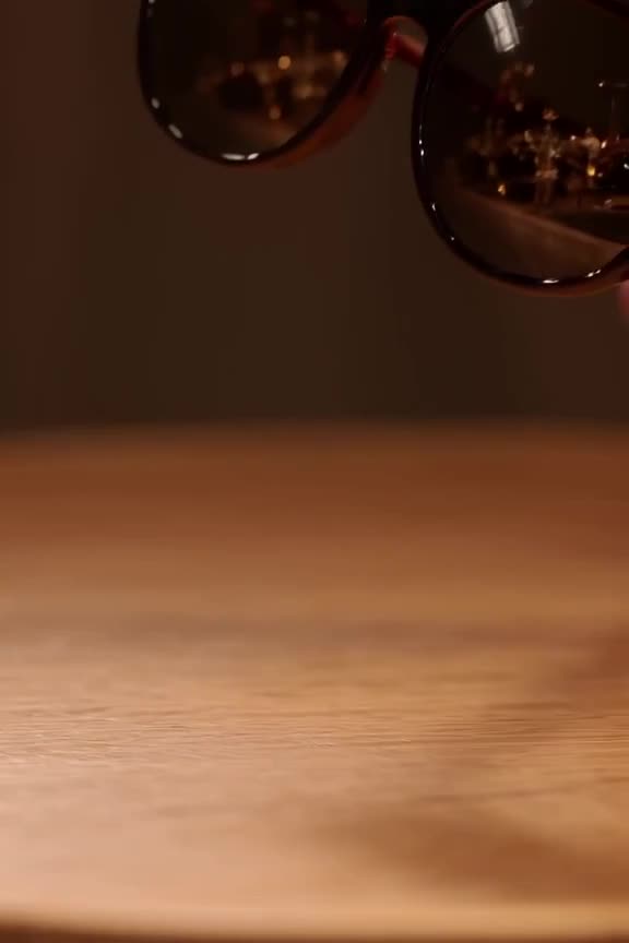 A pair of sunglasses reflects a miniature party scene, which then spills out onto the tab…