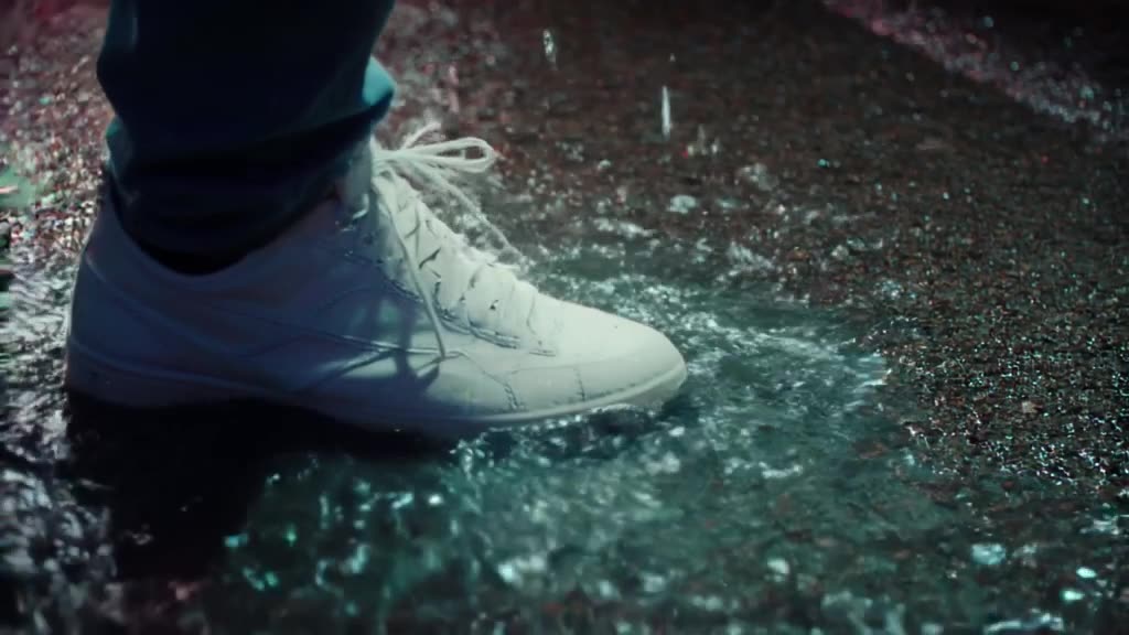 A pristine white sneaker steps into a neon-lit puddle. The splash forms the shape of a sk…