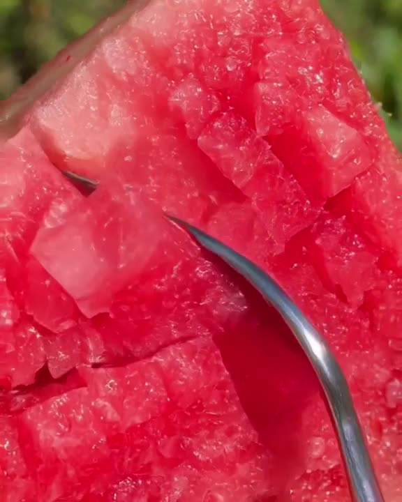 A slice of watermelon is cut, but the red flesh is made of pink glass that shatters into …