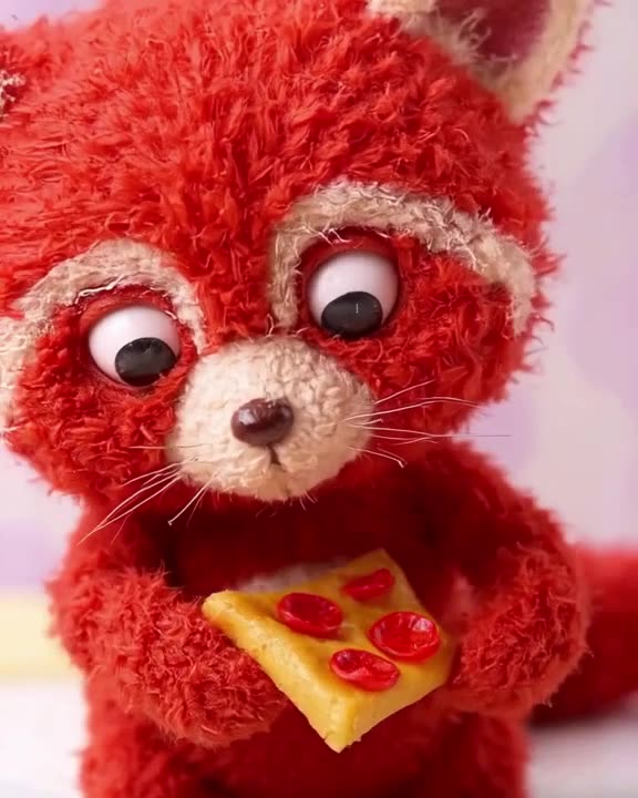 A red panda holds a tiny pizza slice like a gourmet burger. It examines the pepperoni clo…
