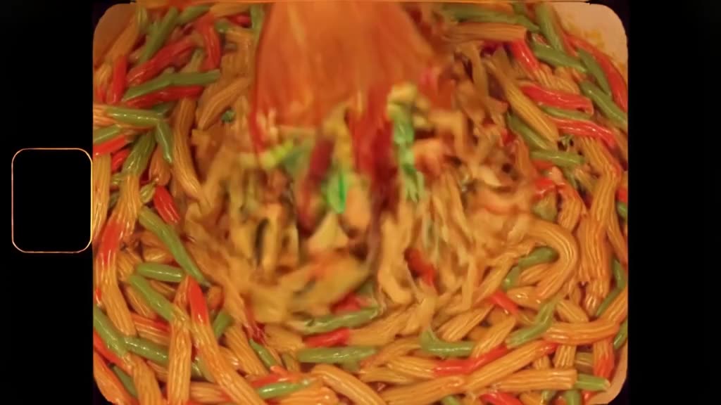 A sneaker is filled with rainbow pasta, which is then stirred with a wooden spoon. The pa…