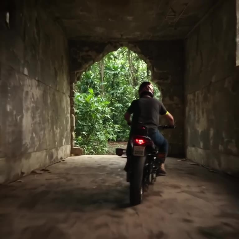 A motorcycle engine roars in a concrete warehouse. The vibration causes the walls to crac…