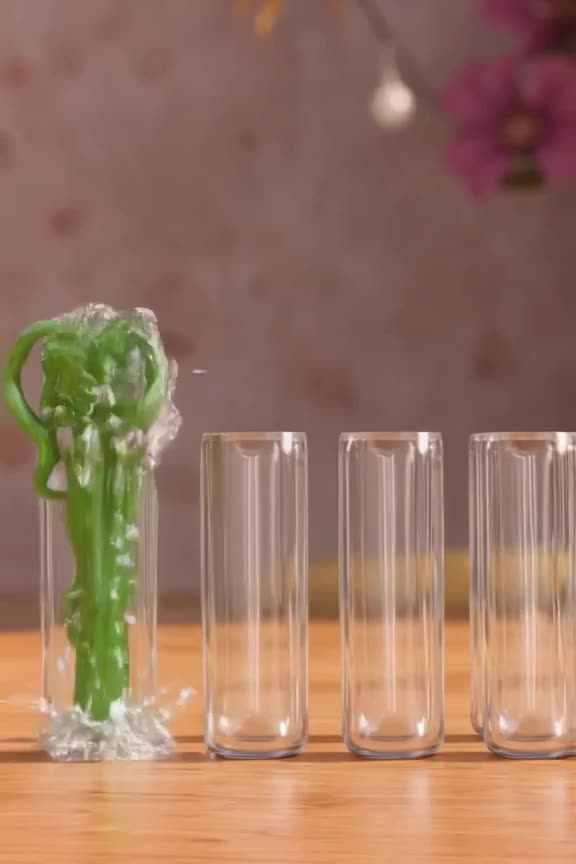 A row of test tubes lined up like dominoes. The first one tips, splashing green liquid th…