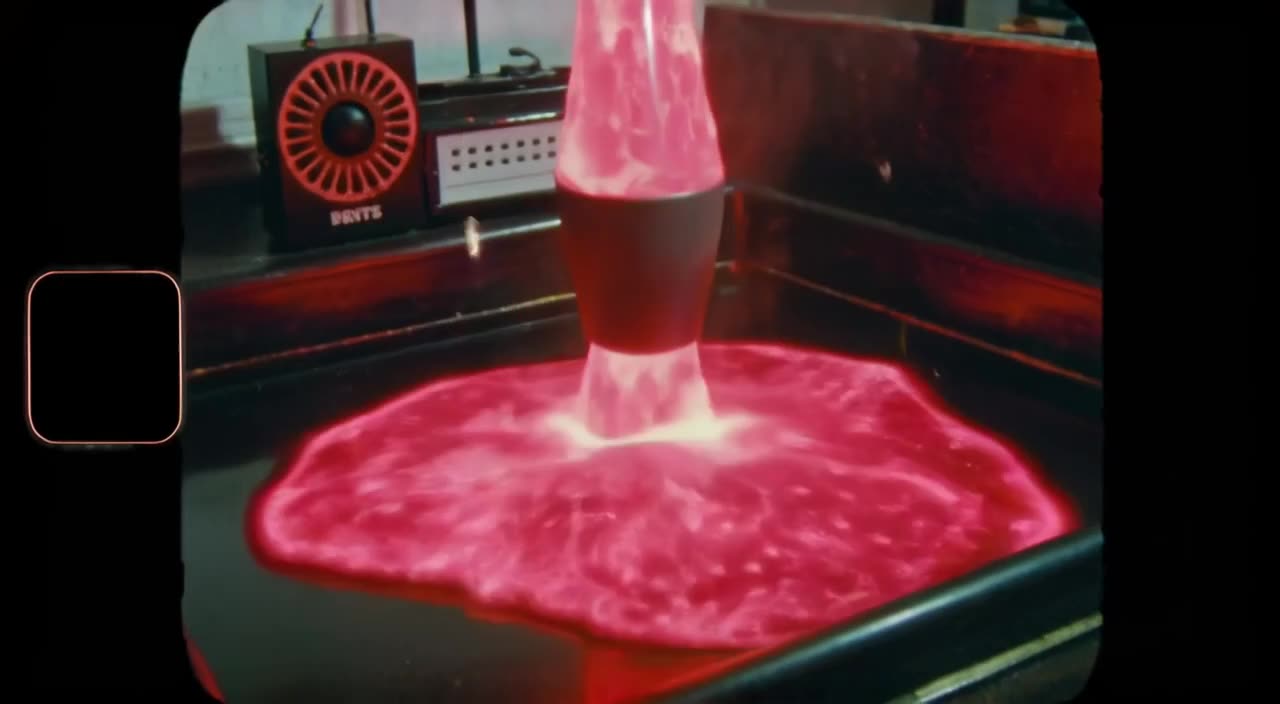 A vintage VHS camcorder records a lava lamp melting into real lava that pools on the floo…